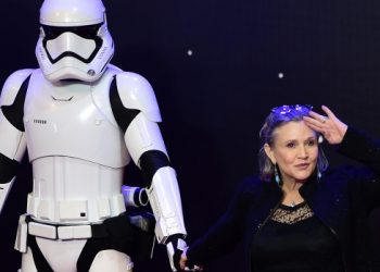 US actress Carrie Fisher (R) poses with a storm trooper as she attends the opening of the European Premiere of "Star Wars: The Force Awakens" in central London on December 16, 2015. Ever since 1977, when "Star Wars" introduced the world to The Force, Jedi knights, Darth Vader, Wookiees and clever droids R2-D2 and C3PO, the sci-fi saga has built a devoted global fan base that spans the generations. 
AFP PHOTO / LEON NEAL / AFP / LEON NEAL        (Photo credit should read LEON NEAL/AFP/Getty Images)